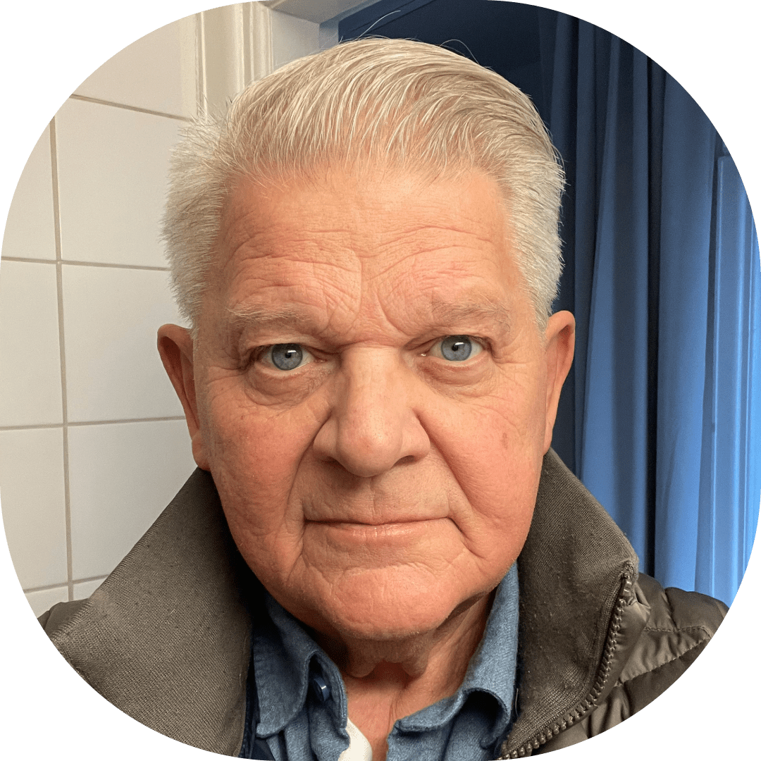 Porträtt av äldre man med grått hår och blå ögon.